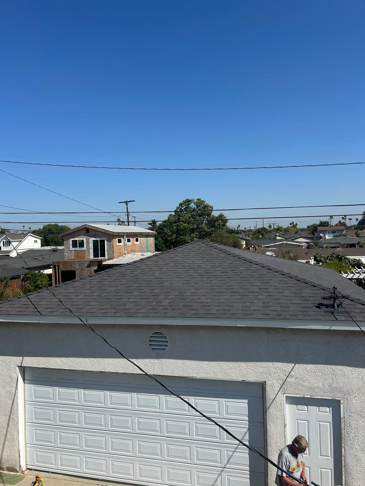 Completed dark gray shingle roof on suburban home